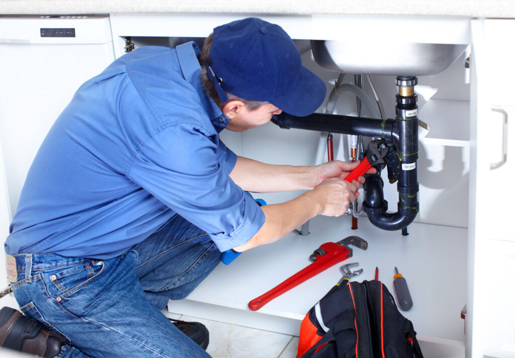A person working on a sinks plumbing