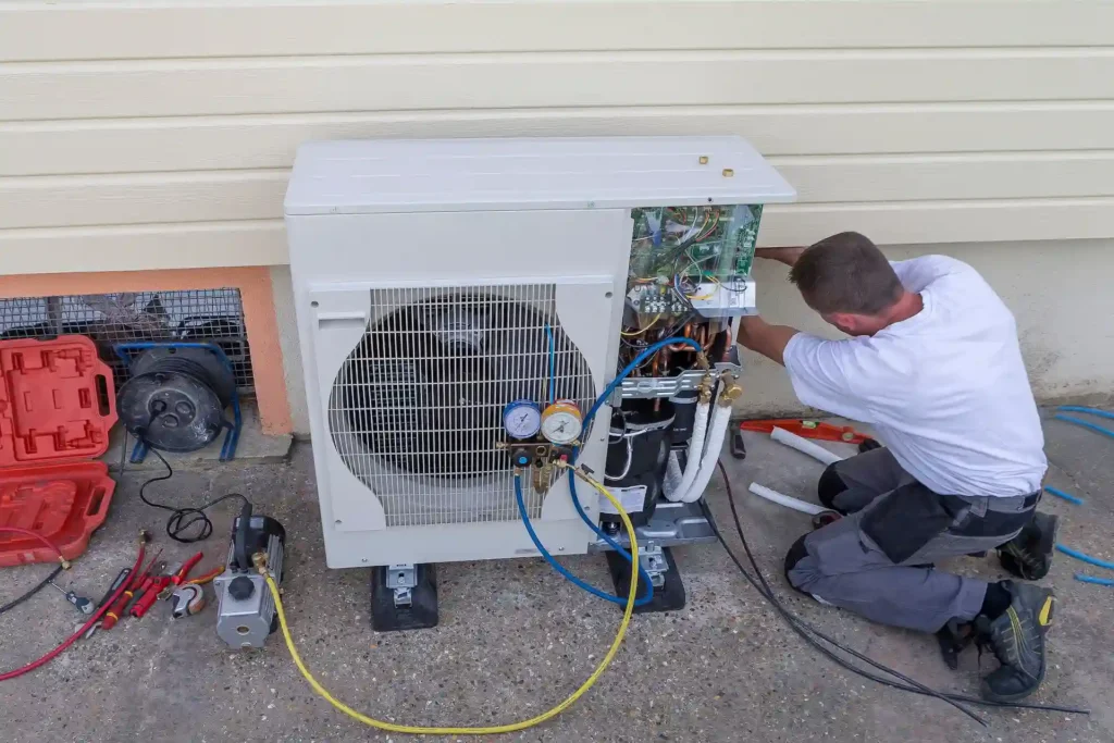 technician working on heat pump in back of home